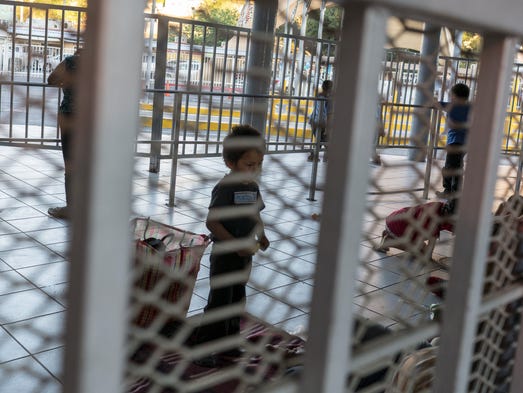 Migrants from Central America wait in line to ask for