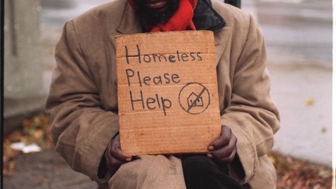 A homeless man panhandles on the corner at The Lodge service drive and Howard in Detroit. The seven mile March Against Homelessness on Sunday was done to raise money for local Homeless Warming Centers. It's theme was "Ending Homelessness one step at a time."