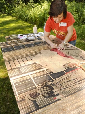 Artist/printmaker Kristin Powers Nowlin of Cape Girardeau, Mo., carves a large scale wood cut during the 2014 Reall Big Prints event at UW-Manitowoc.