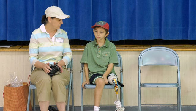 Liam Ollive and his mom, Martha, wait for the assembly at Glenham Elementary School to begin. Students, teachers and staff at the school in Beacon collected cans for deposit and wore hats in support of 4th grader Liam's fight against cancer. They presented the family with a check on Friday, June 6, 2008