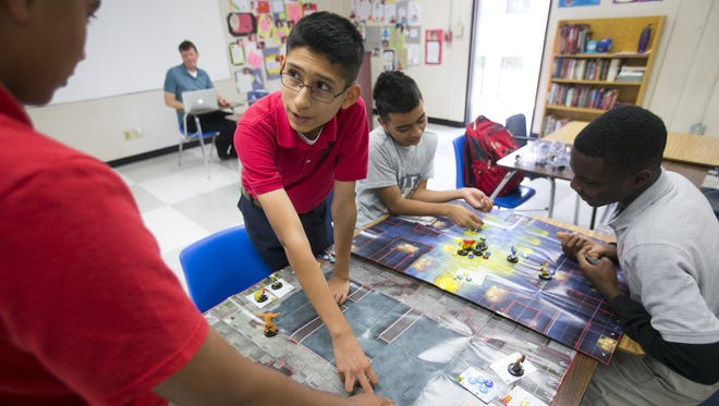 Loyola Academy eighth graders (from left) Valentin Perea, 13, Miguel Valladares, 13, Rudy Felix, 14, and Charles Gbekia, 14, play a strategy game during a humanities class at Loyola Academy on the Brophy Prep campus on Tuesday, May 19, 2015.