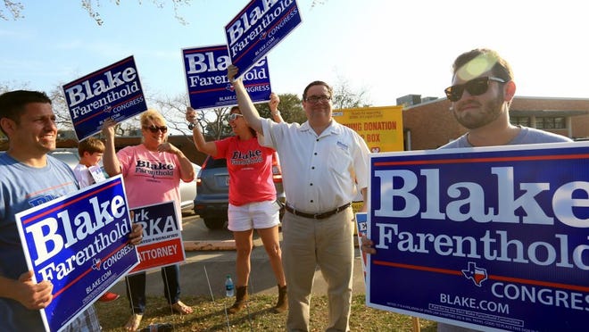 U.S. Representative District 27 incumbent Blake Farenthold waves a sign with supporters as vehicles drive by Tuesday, March 1, 2016, at Montclair Elementary School.