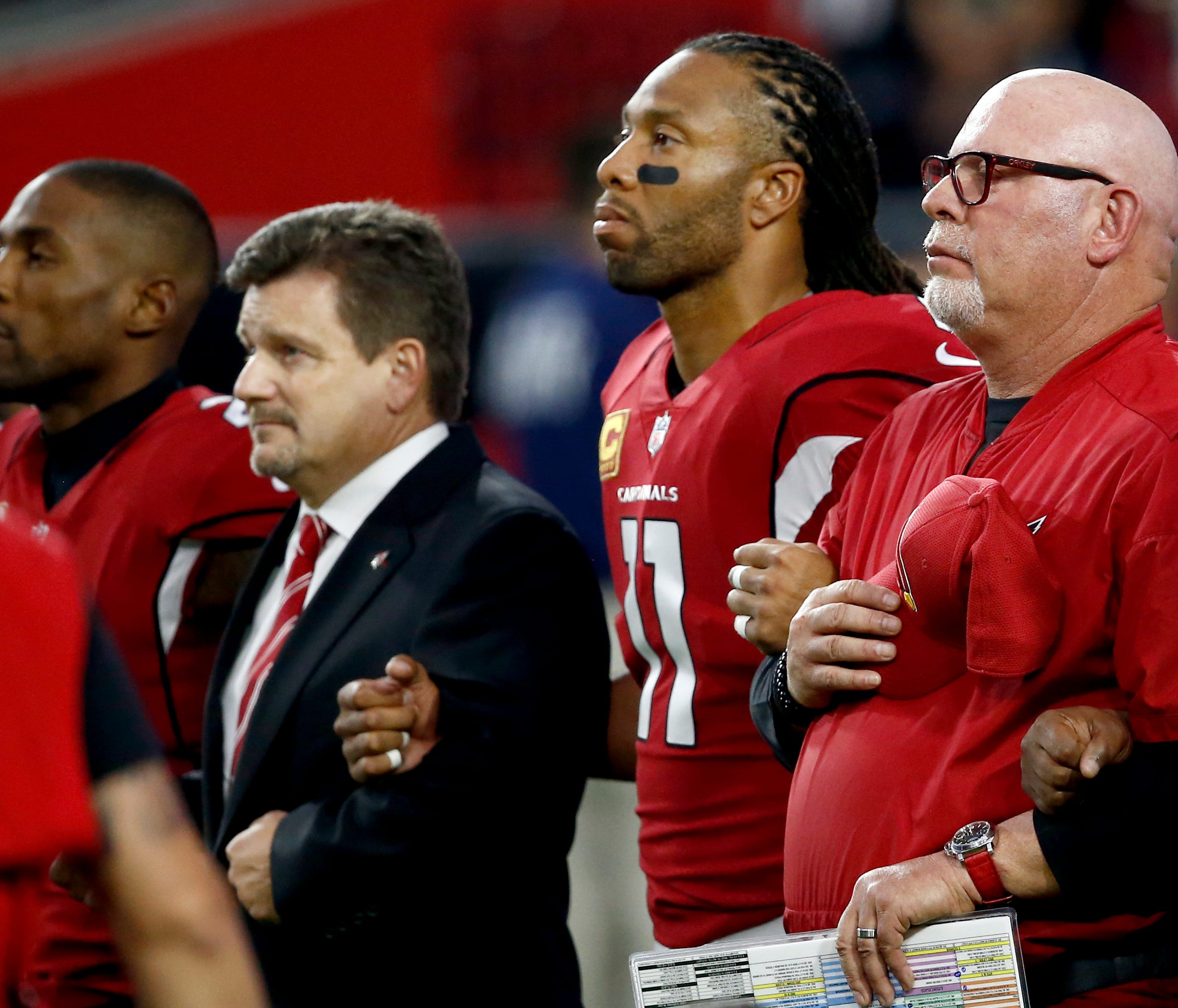 From left; Arizona Cardinals cornerback Patrick Peterson, president Michael Bidwill, wide receiver Larry Fitzgerald and head coach Bruce Arians stand during the national anthem prior to an NFL football game against the Dallas Cowboys, Monday, Sept. 2