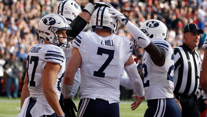 Brigham Young quarterback Taysom Hill (7) is congratulated by teammates after scoring a touchdown against Cincinnati during the first half of an NCAA college football game, Saturday, Nov. 5, 2016, in Cincinnati.