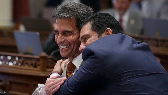 State Sen. Mark Leno, D-San Francisco, left, one of the authors of a bill to raise California's minimum wage, is hugged by Sen. Ben Hueso, D-San Diego, as the Senate voted on the bill, Thursday, March 31, 2016, in Sacramento, Calif. The bill, SB3, to gradually raise the state's minimum wage to a nation-leading $15 an hour by 2022, was approved by both houses of the Legislature and sent to Gov. Jerry Brown.