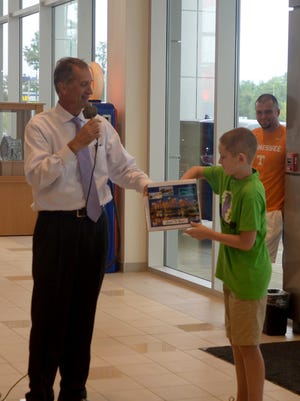 Gabe Parker draws a name from a box held by General Manager Keith Hatchett at Robinson Toyota on Thursday. The winner, who turned out to be Parker, received a trip to Atlantis.
