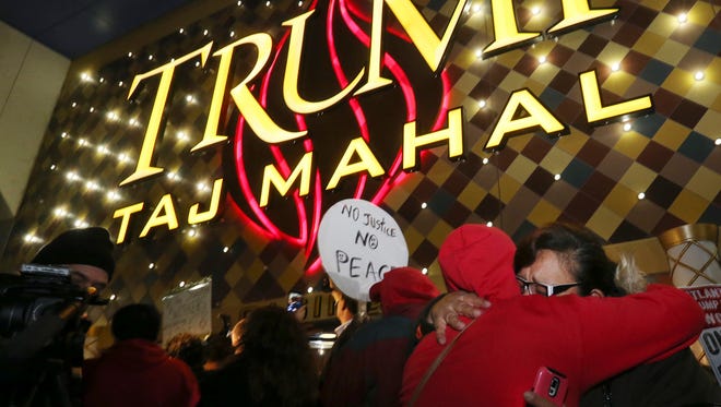 Former employees hug early in the morning outside the closing Trump Taj Mahal Monday in Atlantic City.