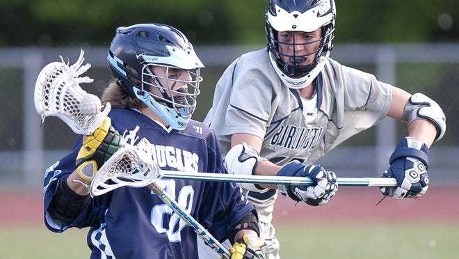 Burlington defender Simon Mendenhall, right, tries to pry the ball free from Mount Mansfield's Jaden Elsinger during Monday's Division II boys lacrosse semifinal at Buck Hard Field.