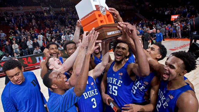 Duke holds up the championship trophy after an NCAA college basketball game against Florida in the Phil Knight Invitational tournament in Portland, Ore., Sunday, Nov. 26, 2017. Duke won 87-84. (AP Photo/Craig Mitchelldyer)