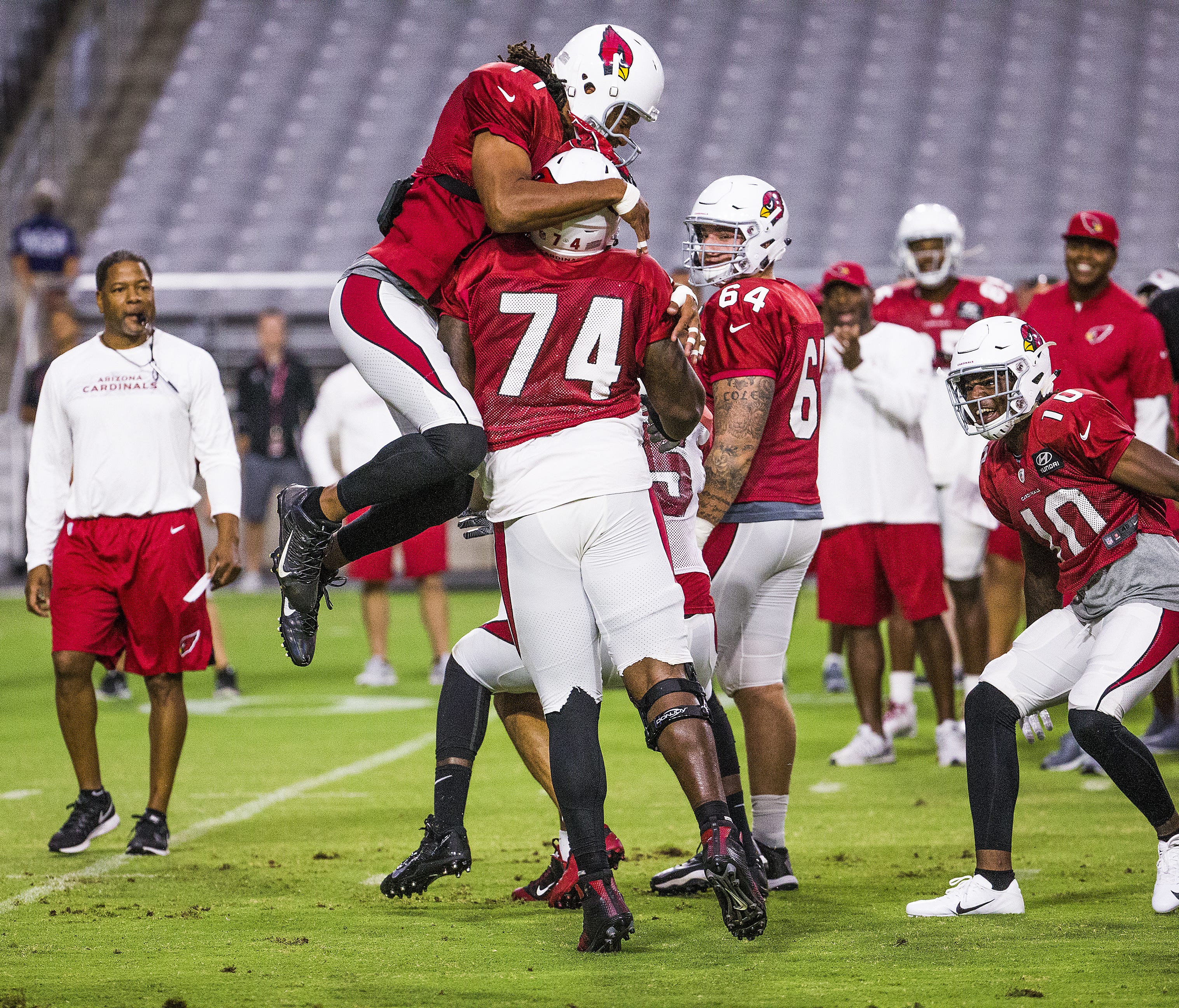 The Arizona Cardinals continue camp at University of Phoenix Stadium in Glendale, Monday, July 30, 2018.  Wide receiver Larry Fitzgerald jumps on top of offensive lineman D.J. Humphries after Humphries blocked defensive end Chandler Jones during one-