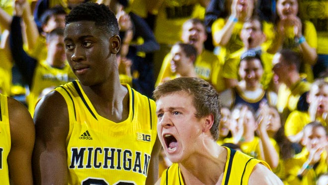 Michigan guard Spike Albrecht celebrates with  Caris LeVert during a time-out in the second half at Crisler Center on Dec. 2, 2014. Michigan beat Syracuse, 68-65.