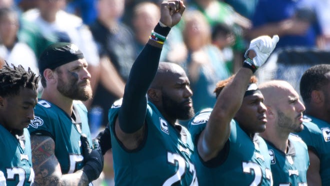 Eagles S Malcolm Jenkins (27) and teammate Rodney McLeod (23) raise a fist during the national anthem before a game last October.