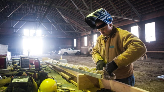 Construction manager Marshall Roos builds support framework inside the Barrel Building, which is being converted into a Peak Health and Fitness in the West Bank Landing development.