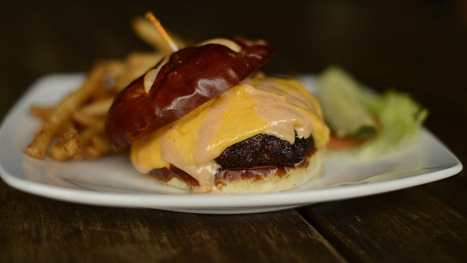 The cheese curd burger, a half-pound patty topped with melted yellow cheese curds and special pub sauce, is among the most popular items at Green Bay Distillery in Ashwaubenon.