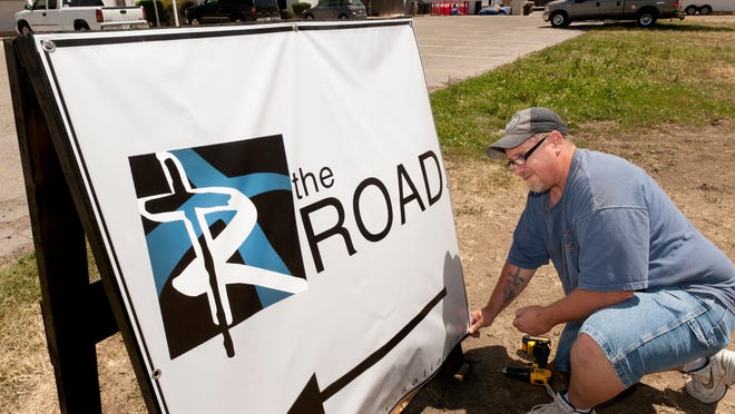 
Marc Behrens assembles a street sign on May 14. 
