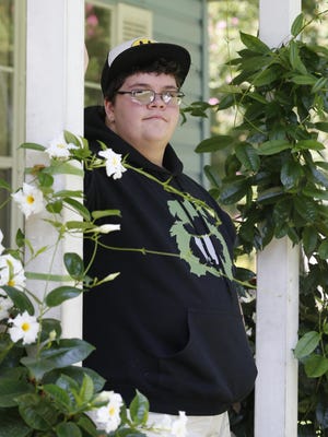 This Tuesday Aug. 25, 2015 photo shows Gavin Grimm poses on his front porch during an interview at his home in Gloucester, Va. Grimm is a transgender student whose demand to use the boys' restrooms has divided the community and prompted a lawsuit. (AP Photo/Steve Helber)