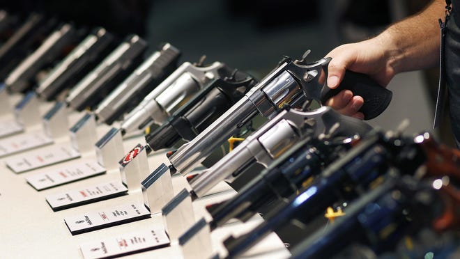 FILE - In this Jan. 19, 2016 file photo, handguns are displayed at the Smith & Wesson booth at the Shooting, Hunting and Outdoor Trade Show in Las Vegas. When gunmakers and dealers gather this week in Las Vegas for the industry's largest annual conference, they will be grappling with slumping sales and a shift in politics that many didn't envision two years ago when gun-friendly Donald Trump and a GOP-controlled Congress took office. (AP Photo/John Locher, File)