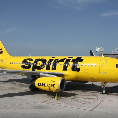 A yellow Spirit Airlines jet parked at an airport 