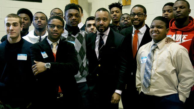 Young men who received free suits and job coaching Saturday at the 10th annualProject Pinstripe program pose with Edmund Lewis, director and founder of Minority Males for Higher Education.
