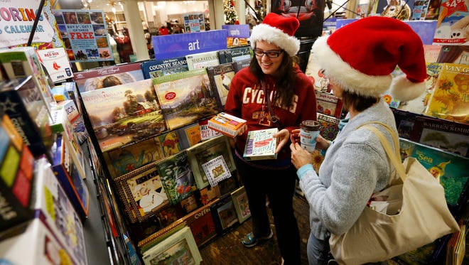 Sarah Menzel (center) and mother, Denise Menzel, look through calendars Friday, Nov. 27, 2015, as they try to find Black Friday deals at Valley West Mall in West Des Moines.