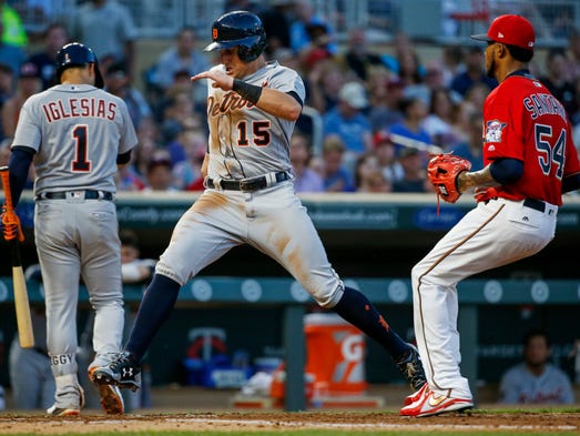 Tigers centerfielder Mikie Mahtook, center, scores