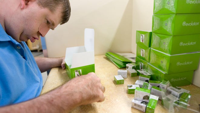 Troy Bennett, who is developmentally disabled, sorts tea boxes at the Marc Center work program in 2009.