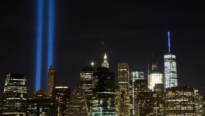 The "Tribute in Light" illuminates the skyline of Lower Manhattan as seen from the Brooklyn Heights Promenade, September 11, 2016 in New York City.