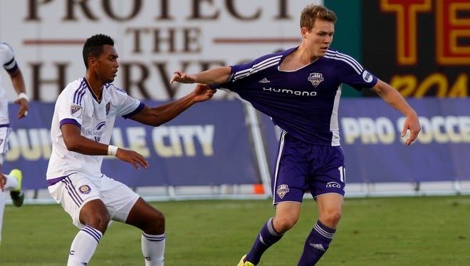 Louisville City's Magnus Rasmussen, #10, right, tries to get loose as Orlando City's Tommy Redding, #29, yanks on his jersey during their game at Slugger Field.Aug. 25, 2015