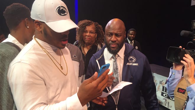 Micah Parsons talks to coach James Franklin as he looks over his signed letter-of-intent to attend Penn State and play football for the Nittany Lions. He's pictured next to his father, Terrence, a long-time Penn State fan.