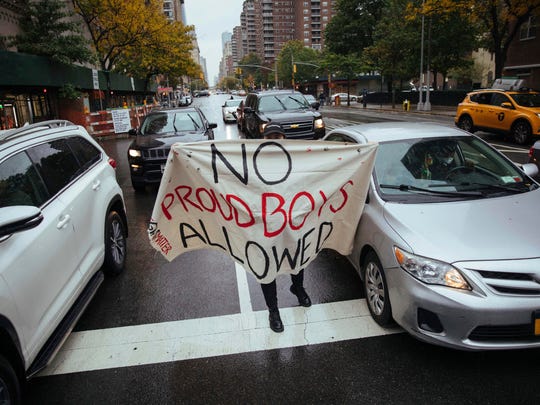 A motorist holds a homemade anti-Proud Boys sign during an anti-fascist and anti-Trump march Sunday in New York. The march was organized in response to the concurrent MAGA Drag, a car caravan in support of Donald Trump.