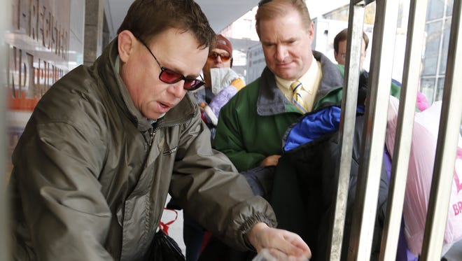 Longtime Register sports staffer Bryce Miller, left, and publisher Rick Green sort a donation of coats as part of the Register's "Keeping Our Kids Warm" coat drive in 2012.