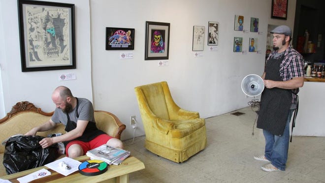 Carl Grutt, seated left, and Will Ashton, right, discuss lighting for a blacklight art show to be held at Gallery K and Coffeehouse. June 24, 2015