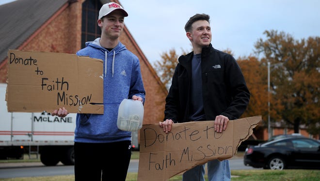 Midwestern State freshmen and Kappa Sigma Fraternity pledges Bailey O'Dell, left, and Joey Chrysanthopoulos hold signs asking people to donate to Faith Mission Friday, Nov. 10, 2017, at MSU on the corner of Taft and Hampstead.