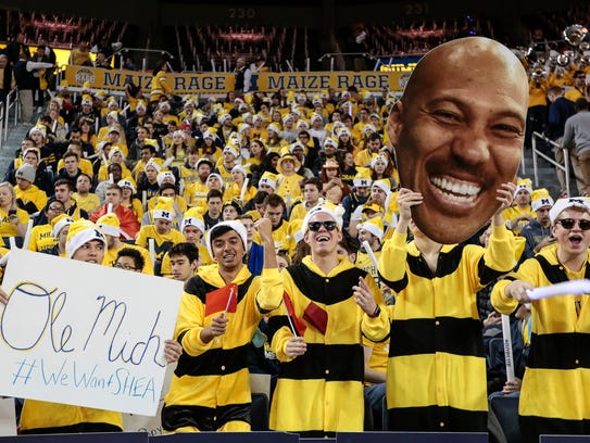 Michigan fans holds a sign of #WeWantSHEA, referring