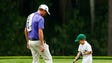 Webb Simpson watches his son putt on the ninth green