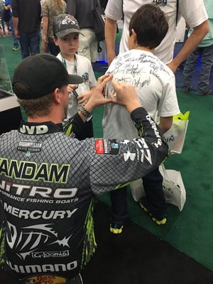 Jonathan VanDam signs autographs for fans during the Bassmaster Classic.