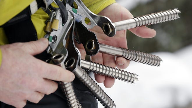 Ice climber Don Mellor checks his ice screws before climbing Pitchoff Quarry in Keene, N.Y.