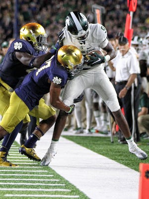 Michigan State wide receiver Donnie Corley (9) is pushed out of bounds after a catch by Notre Dame cornerback Nick Watkins (7) during the first half Saturday in South Bend, Ind.