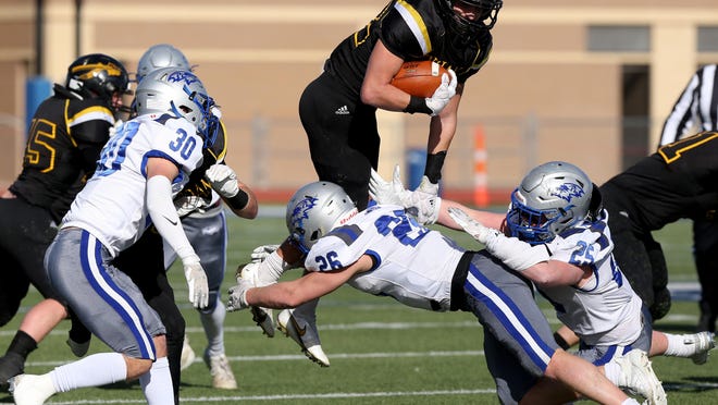 Andale's Elijah Rowland (22) is tackled in the air by Perry-Lecompton's Thad Metcalfe (26) and Ryley Besler (25) during their Class 3A State Championship game at Gowans Stadium in Hutchinson Saturday afternoon. Andale defeated Perry-Lecompton 20-0.