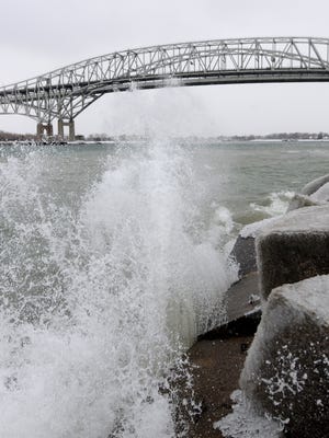 Waves crash into the shore near the Blue Water Bridge Monday in Port Huron.