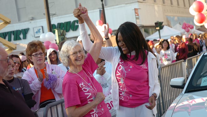 Breast cancer survivors Jacque Caplan (left) and Janice Joseph-Richard raise their hands before the start of the 2010 race in this Town Talk file photo. Caplan died on Saturday at age 81.