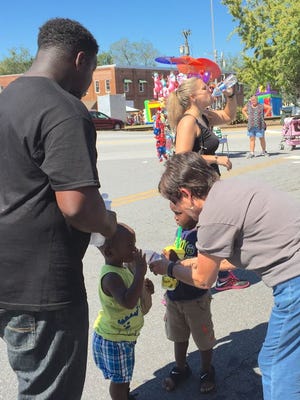 A Poplar Springs Baptist Church member helps a toddler to a bottle of water.