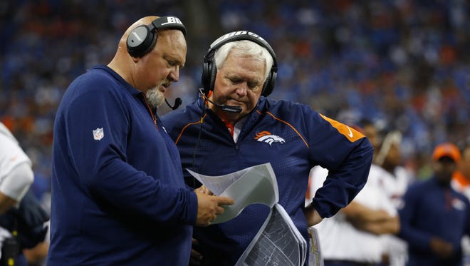 Broncos defensive coordinator Wade Phillips and linebackers coach Reggie Herring talk during their game against the Lions.