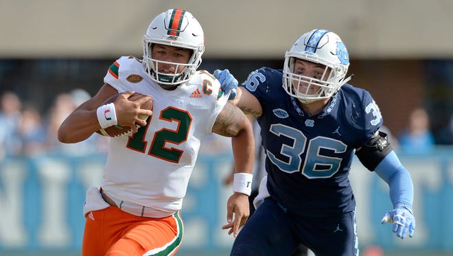Miami's Malik Rosier breaks away from North Carolina's Cole Holcomb on Saturday during the Hurricanes' 24-19 victory. The victory extended Miami's best-in-the-nation winning streak to 12 games.