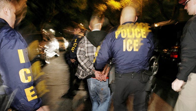 Immigration and Customs Enforcement (ICE) officers arrest a suspect during a pre-dawn raid in Santa Ana, Calif., in this file photo from Wednesday, Jan. 17, 2007.  The Census Bureau plans to ask immigration enforcement officials to suspend raids during the 2010 census to help improve accuracy in counting illegal immigrants.