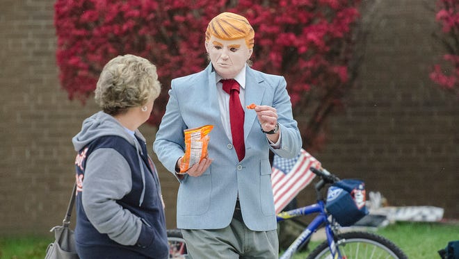 Perennial Livonia political gadfly Leo Weber works the polls at Frost Middle School wearing a Donald Trump mask and passing out candy.