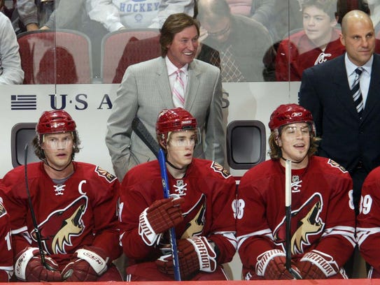 Wayne Gretzky and Rick Tocchet stand behind the Coyotes