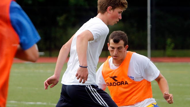 Junior Seth Schuster, left, and senior Doug Popper battle for possession of the ball during soccer practice at Blind Brook High School, Aug. 21, 2014 in Rye Brook.