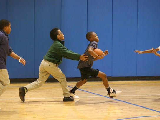 Anttwan Brown, center, plays football in the gym with
