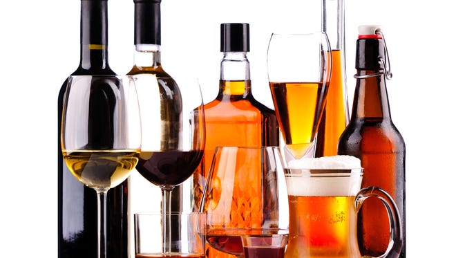 different bottles and glasses of alcoholic drinks isolated on a white background
